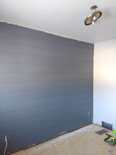 a room that is being remodeled with blue paint on the walls, and a light fixture hanging from the ceiling