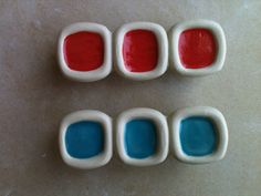 three red, white and blue buttons sitting next to each other on top of a table