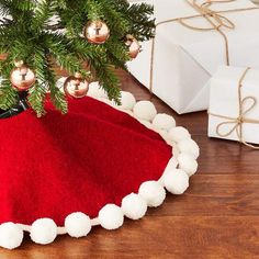 a christmas tree skirt with pom - poms under it