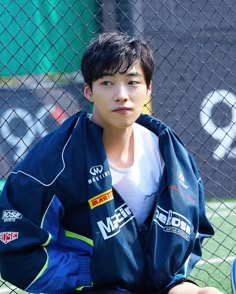 a young man sitting on top of a tennis court