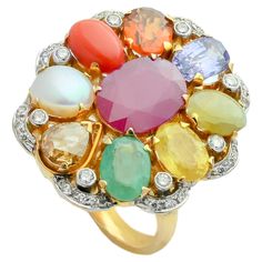 A simple 18K gold ring in the form of oval shape set with the nine planetary gems (navratna) and full cut diamonds. Starting with blue sapphire at the lower end, the nine gemstones include a coral, yellow sapphire, emerald, cat's eye, cultured pearl, hessonite garnet, blue sapphire and a natural ruby at centre. The concept of navratna is born at the core of Indian hindu culture, to attain the maximum prophylactic powers of the nine gems, the gems need to be set with open-back mounts so that light passed through the stones transmitting their energies to the body. The ring embodies nearly 11.50gms of fine gold and 14.21cts of natural stones accompanied with 0.60cts diamonds. Luxury Multicolor Oval Gemstones, Fine Jewelry Multicolor Oval Gemstones, Luxury Oval Multi-stone Diamond Ring, Heirloom Multicolor Oval Jewelry, Exquisite Multi-stone Diamond Gemstones, Luxury Multicolor Ruby Ring, Multicolor Oval Gemstones For Anniversary, Oval Multicolor Gemstones For Anniversary, Oval Multicolor Multi-stone Rings