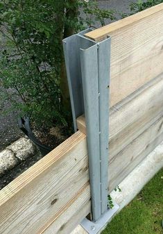 the side of a wooden fence that has been made out of wood and metal posts