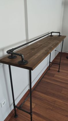 a wooden table with two metal pipes on it and a wood floor in the background