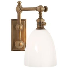 an antique brass wall light with white glass shade