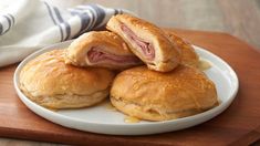 ham and cheese pastries on a white plate with a striped dish towel in the background