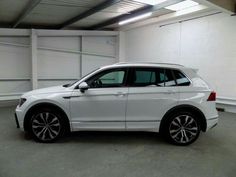 a white volkswagen tigua parked in a garage