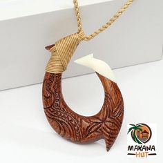 Hand made Hawaiian Makau (Fish Hook) Pendant made of Koa Wood and Bone featuring tribal engravings. Designed in Hawaii and has brown adjustable cord.  #makau #hawaiianjewelry #fishhooknecklace #handmadejewelry Hawaiian Artwork, Maori Necklace, Beginner Wood Burning Pattern, Bone Fish, Bone Ornament, Beginner Wood Burning, Fish Hook Necklace, Maori Designs, Volcanic Ash