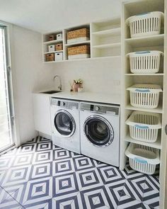 a washer and dryer sitting in a room next to some shelves with baskets