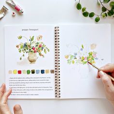 a person holding a paintbrush and drawing flowers in a book with watercolors