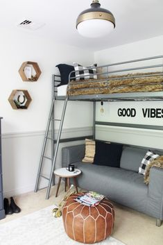 a living room with a couch and bunk bed next to a ladder that reads good vibe