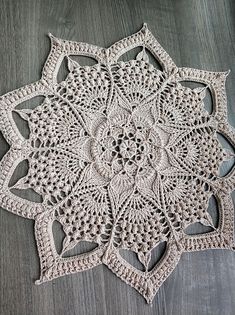 a crocheted doily on a wooden surface