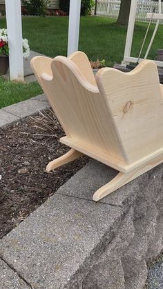 a wooden sled sitting on top of a stone wall next to a flower bed