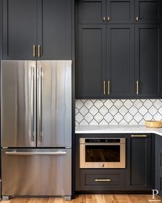 a metallic refrigerator freezer sitting inside of a kitchen next to wooden floors and cabinets