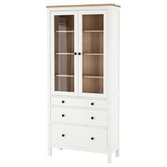 a white cabinet with glass doors and drawers on the bottom, in front of a white background