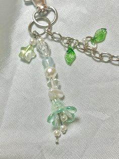 a green and white beaded necklace on a silver plated chain with glass beads