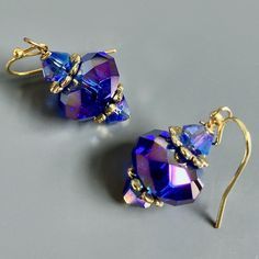 "Purple and Gold  Earrings - Glass Iridescent Purple  Beads with Gold Plated Beadcaps and Iridescent Purple Bacon Glass Beads. These earrings have a lot of sparkle and are gorgeous when the light hits them. The Beads are approximately 14mm wide Gold plated Earwires Earrings measure  1.25\" long from top of earwire to bottom" Faceted Crystal Earrings For Party, Dangle Wire Wrapped Crystal Earrings For Party, Elegant Handmade Iridescent Earrings, Handmade Iridescent Crystal Earrings For Party, Party Wire Wrapped Beaded Earrings, Pierced Iridescent Jewelry For Party, Faceted Dangle Earrings For Party, Elegant Handmade Iridescent Beaded Earrings, Iridescent Pierced Jewelry For Party