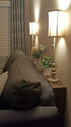 a living room filled with furniture and two lamps on either side of the window sill