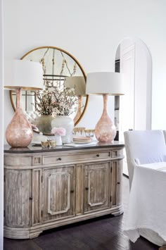 a dining room table with vases and lamps on it