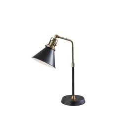 a black and gold desk lamp on a white background, with the light turned off