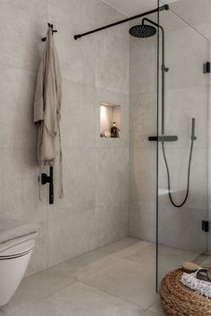 a bathroom with a shower, toilet and towel on the rack next to the sink