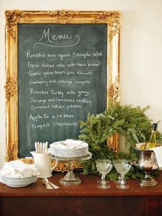 a table with plates and silverware on it next to a chalkboard that says menu