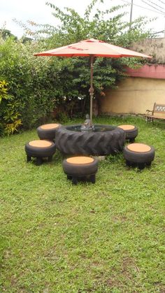 a group of tires sitting on top of a lush green grass covered field next to an umbrella