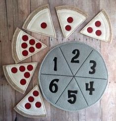 a clock made out of felt with numbers and pizza slices in the middle on a wooden floor