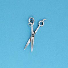 a pair of scissors sitting on top of a blue surface