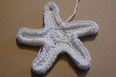 a white crocheted starfish ornament on a table