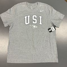 Show Your Support For The University Of Southern Indiana Eagles, Usi With This Brand New Nike Shirt. Perfect For Any Fan, This Gray Tee Comes In A Comfortable X-Large Size And Features The Usi Logo Prominently On The Front. Xl Adult Mens Size. Whether You're Heading To A Game Or Just Want To Represent Your Favorite Team, This Shirt Is A Must-Have For Any Eagles Fan. Light Gray, Grey Color. Short Sleeve Men’s. M11332 Made From High-Quality Materials, This Nike Shirt Is Designed To Last And Keep Y Nike Cotton Shirt With Relaxed Fit, Relaxed Fit Cotton Nike Shirt, Nike Cotton T-shirt For College, Nike Gray Tops With Letter Print, Nike Cotton Shirt With Letter Print, Nike Gray T-shirt With Logo Print, Nike Gray Cotton Tops, Nike Gray Crew Neck Shirt, Nike Gray Short Sleeve Shirt