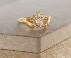 a close up of a gold ring with a heart shaped diamond in it's center