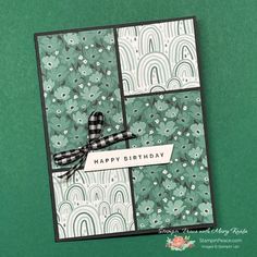 a birthday card with green and white flowers on it, featuring a black ribbon that says happy birthday