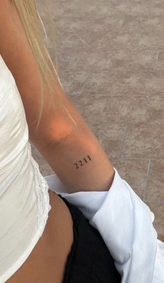 a woman with a small tattoo on her left arm and the word fizz written in it