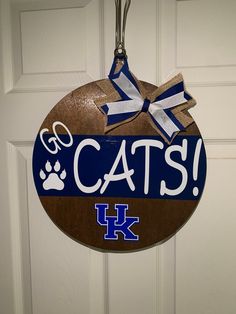 a cat's door hanger with the word cats on it