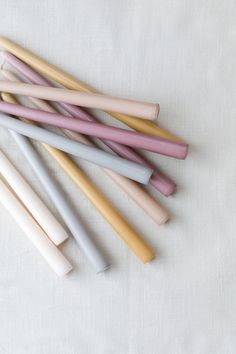 five different colored toothbrushes lined up on a white surface with one being pink, the other is blue