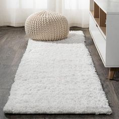 a white rug on the floor in front of a window