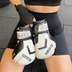 a woman wearing white and black boxing gloves