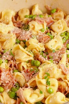 a bowl filled with pasta and peas on top of a table