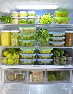 an open refrigerator filled with lots of different types of vegetables and fruits in plastic containers