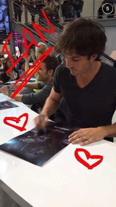 a man sitting at a table with red marker marks on it