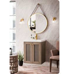 a bathroom vanity with a round mirror on the wall above it and a chair next to it