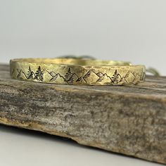 Celebrate 21 years together with this solid brass cuff bracelet with hand engraved mountains and trees to signify your lasting love. To make it even more special, add a personalized message on the inside. This solid brass bracelet is 6 inches long, and 1/4 inch wide. It is a solid 12 gauge brass bracelet that is comfortable to wear and perfect for every day. Mountains And Trees, 21st Anniversary, Tally Marks, Bronze Bracelets, Brass Cuff Bracelet, 10th Wedding Anniversary, Brass Cuff, Pagan Jewelry, Lasting Love