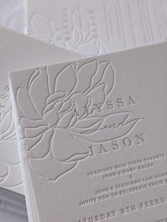 the wedding stationery is laid out on top of each other, with white paper