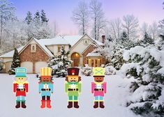 a group of nutcrackers standing in front of a house covered in snow