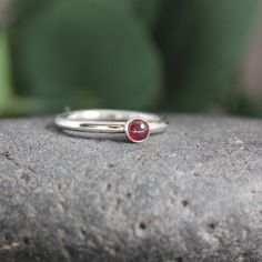 Garnet symbolizes love and is the gemstone to give for the 2nd anniversary. It is also the birthstone for January. This simple sterling silver stacking ring is a great gift, or an addition to a collection of stacking rings. Here are the details: This ring is made with a 4mm or 5-6mm bezel set garnet cabochon set on a sturdy sterling silver band handmade in your size. It can be worn with other stackable rings, or by itself.Please select your ring size. Sizes are US based. May Birthstone Stackable Rings For Gift, May Birthstone Stackable Round Rings, Classic Everyday Stackable Gemstone Rings, Fine Jewelry Sterling Silver Stackable May Birthstone Rings, Sterling Silver Solitaire Birthstone Ring Gift, Classic Everyday Sterling Silver Birthstone Ring, Sterling Silver Solitaire Birthstone Ring As A Gift, Silver Stackable Rings For May Birthstone, Gift Stackable Rings With Bezel Setting And Round Stone