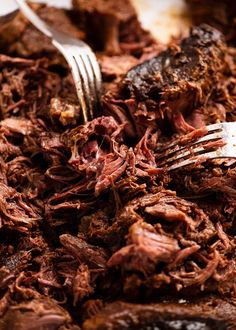 a close up of a plate of food with meat and a fork next to it