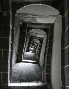 an empty hallway with light coming in from the end