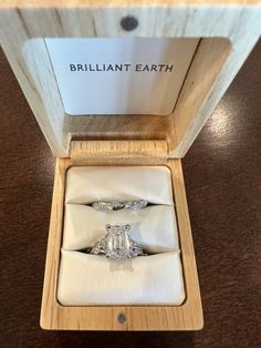 two engagement rings sitting in a wooden box