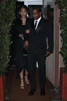 the man and woman are walking out of the door to their wedding reception in black attire