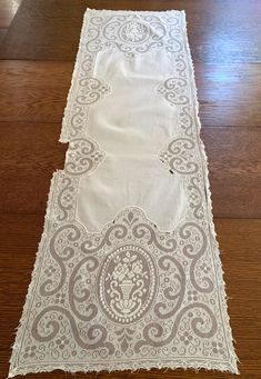 a white table runner on top of a wooden floor